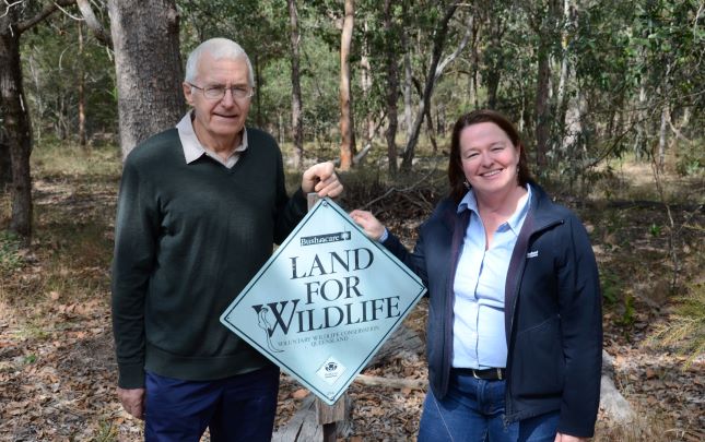 Land for Wildlife participant standing next to a sign with Redland City Council Officer.