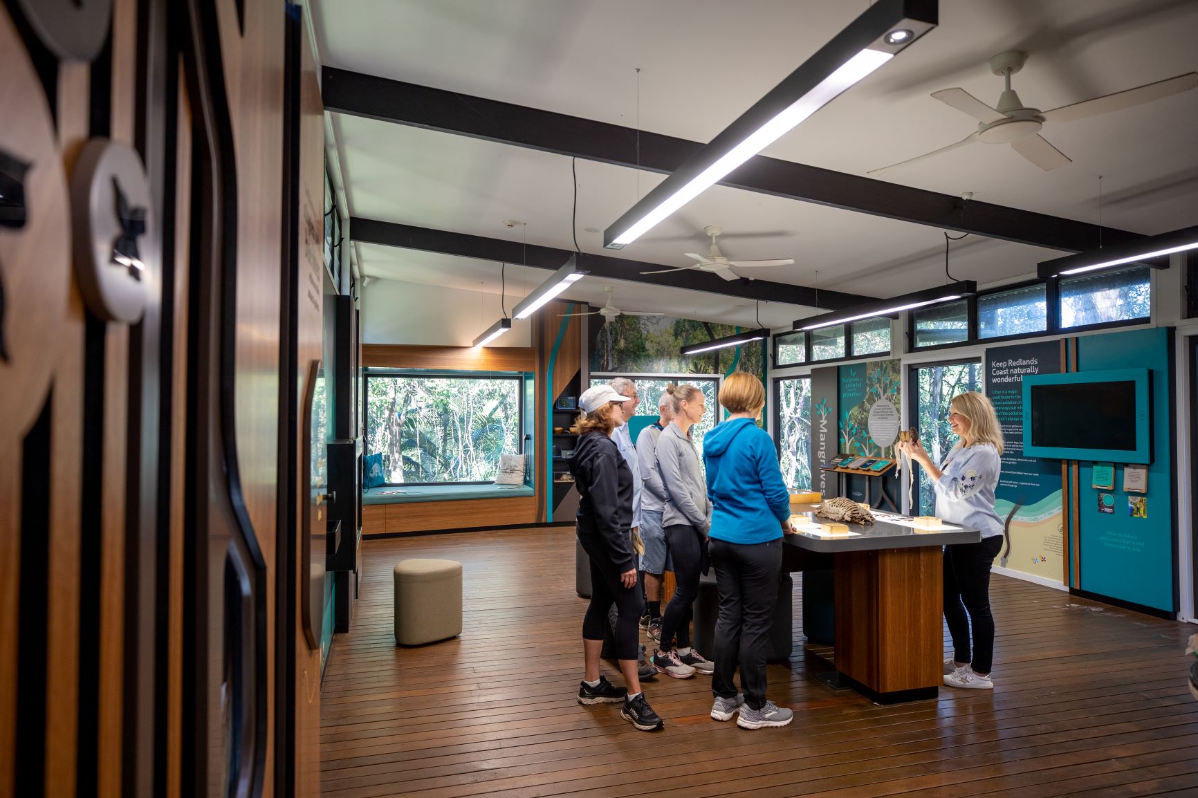 Ranger Stacey in the Discovery Centre showing a group of people a snake skin.